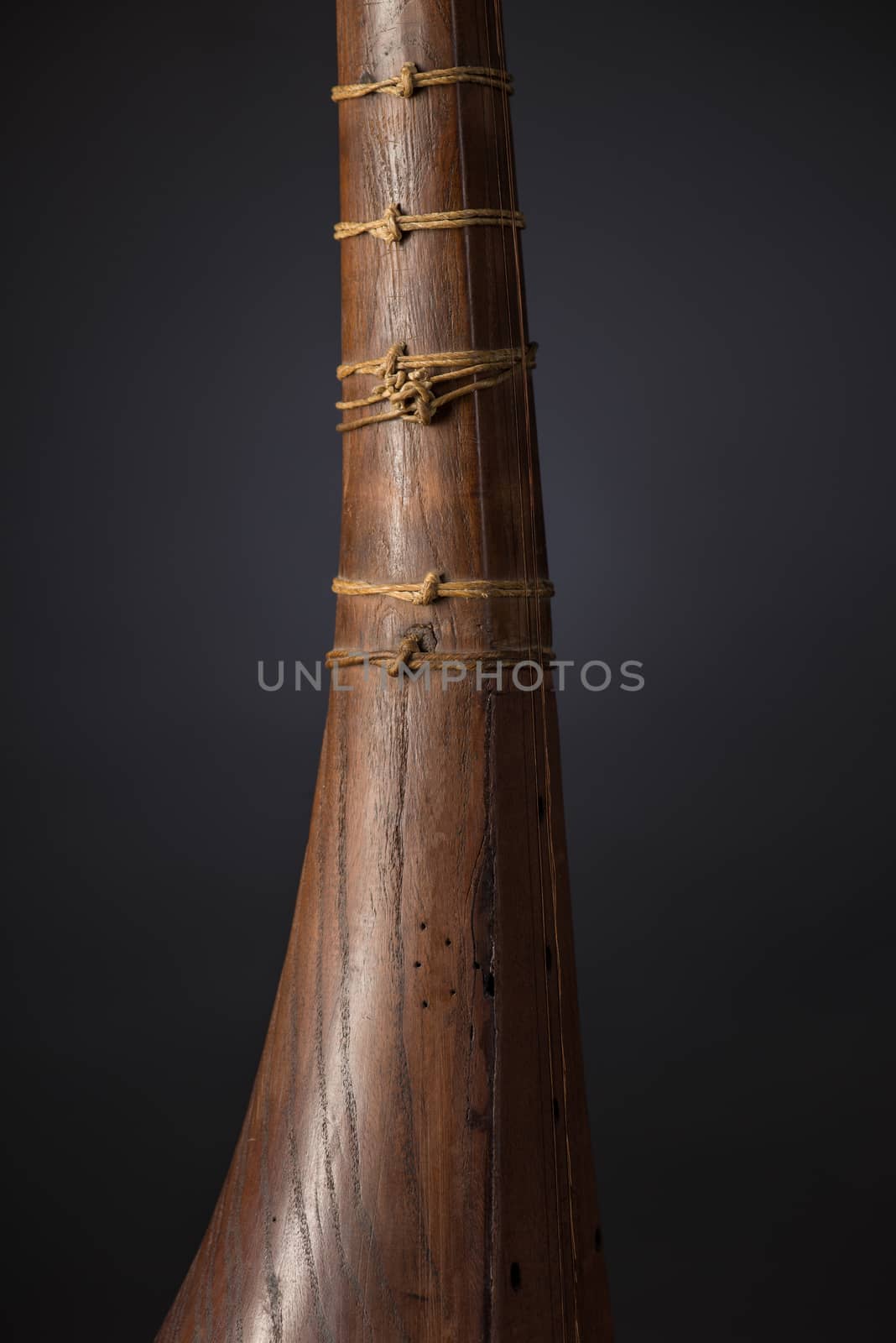 part ancient Asian stringed musical instrument on black background with backlight