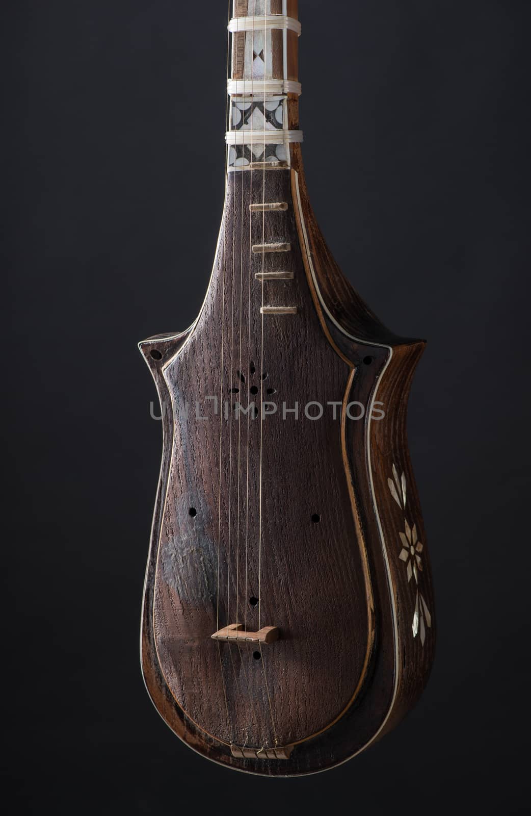 part ancient Asian stringed musical instrument on black background with backlight