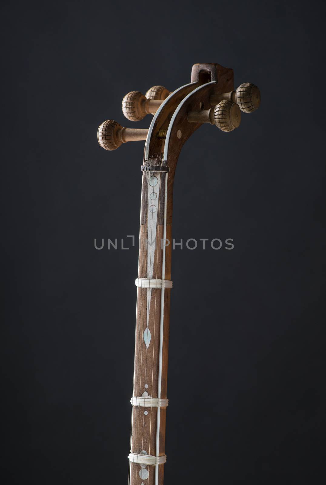 ancient Asian stringed musical instrument on black background with backlight. tuning peg