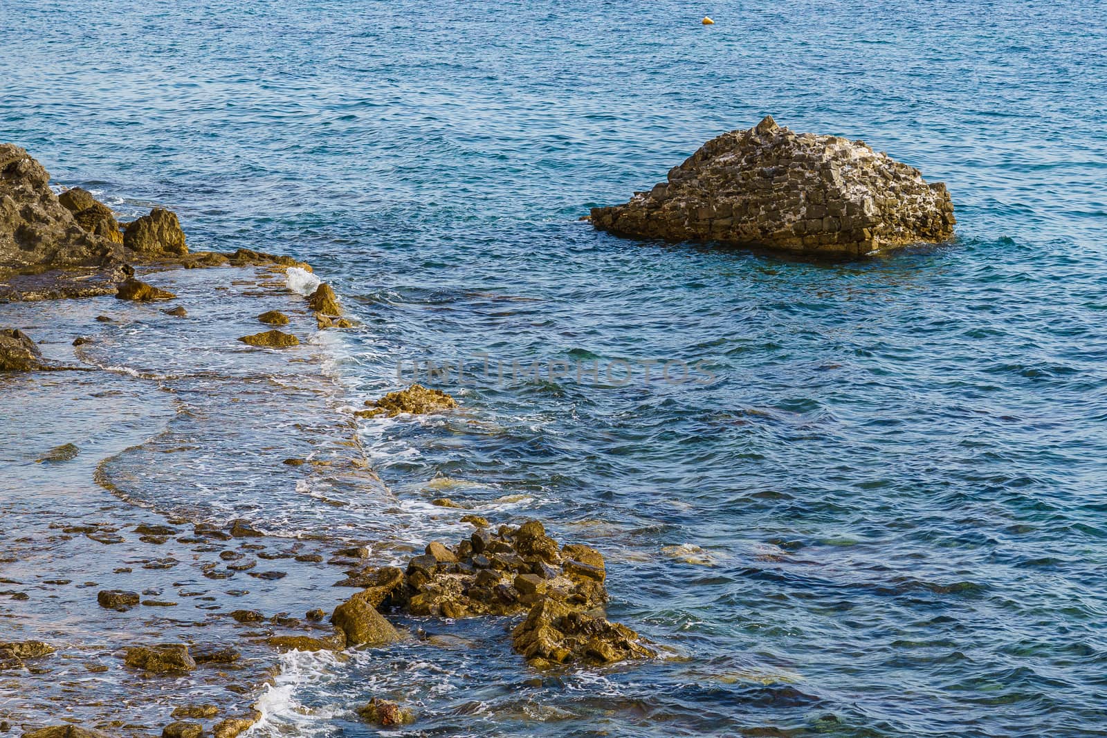 Sea shore. Stones and surf, summer day