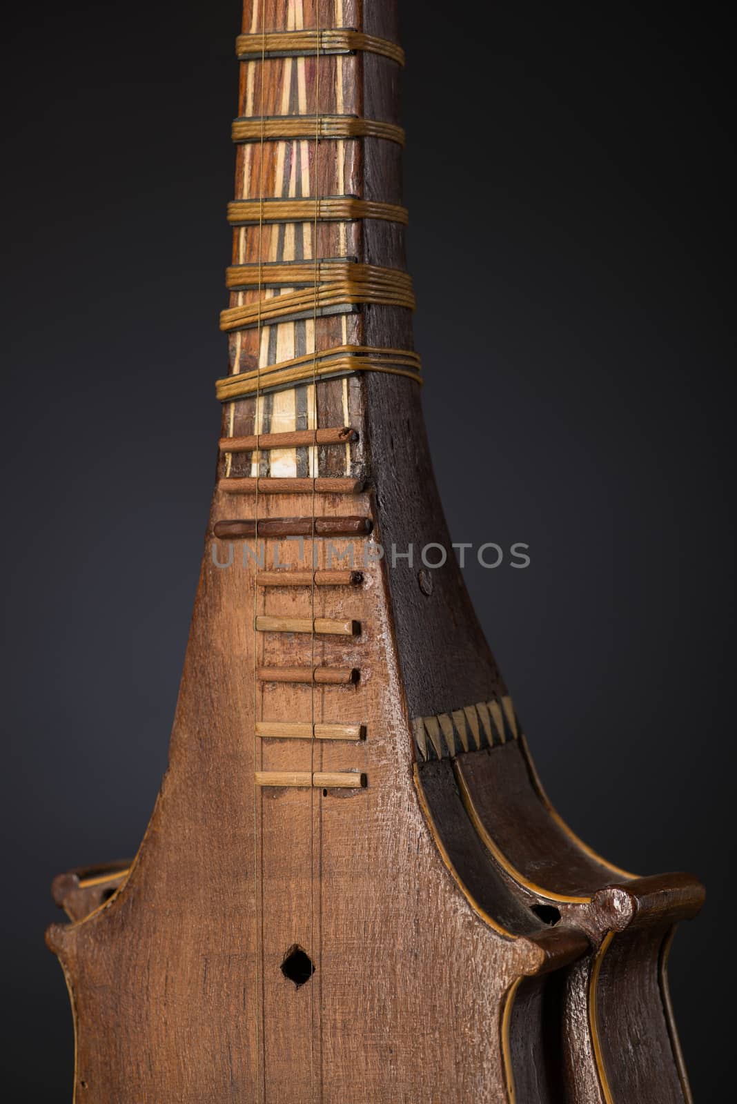 part ancient Asian stringed musical instrument on black background with backlight