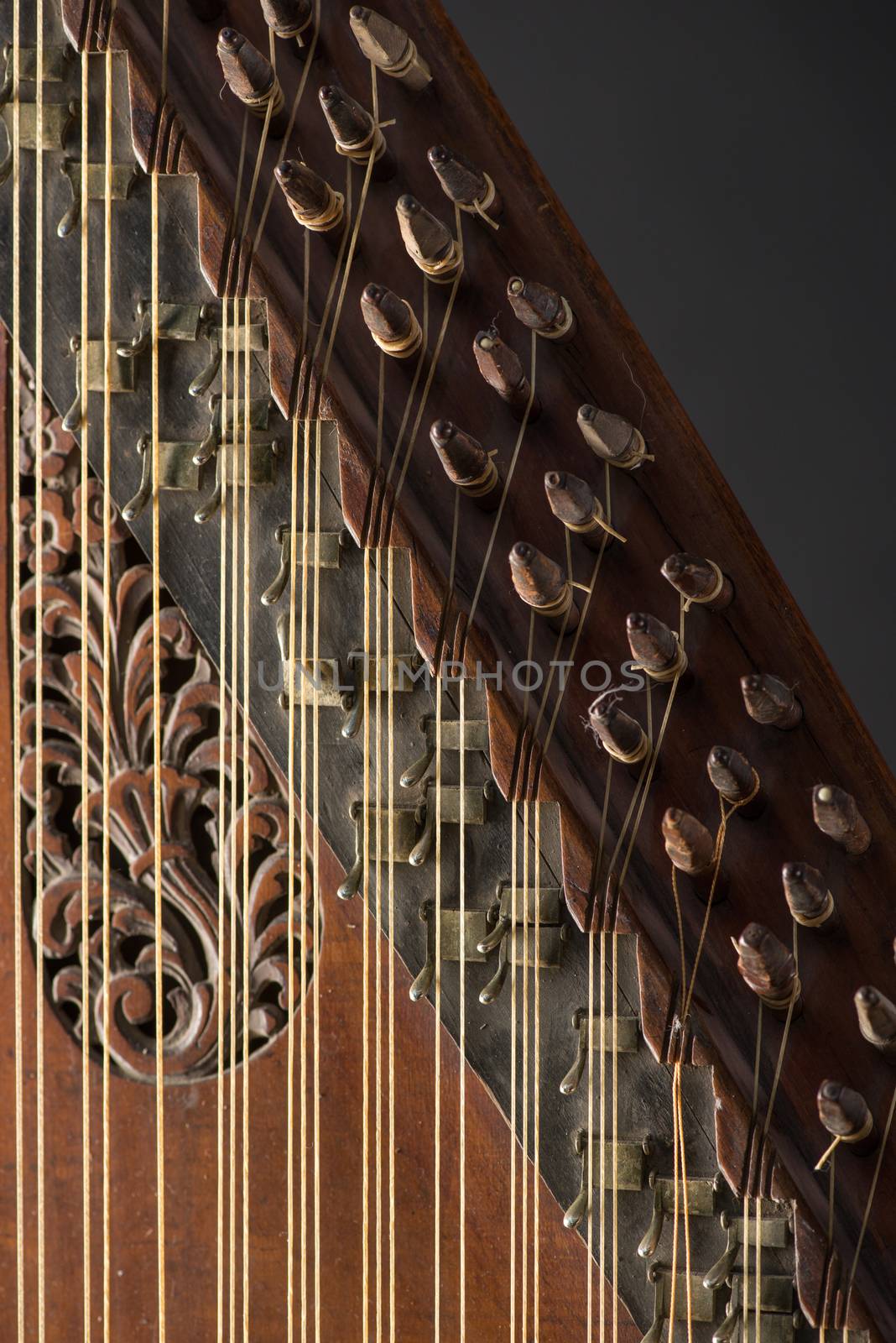 ancient Asian stringed musical instrument on black background with backlight. the similarity of the harp and psaltery. close-up