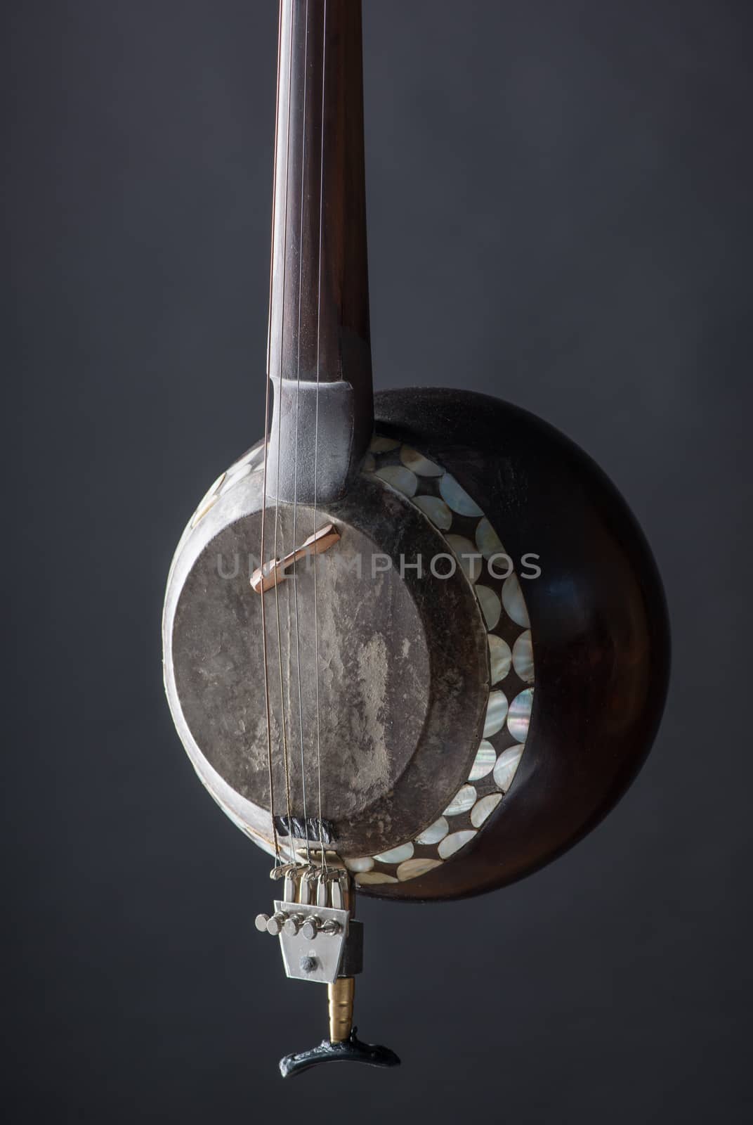 part ancient Asian stringed musical instrument on black background with backlight