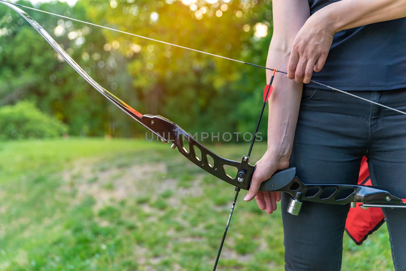 stretching an arrow in a bow during archery in nature.