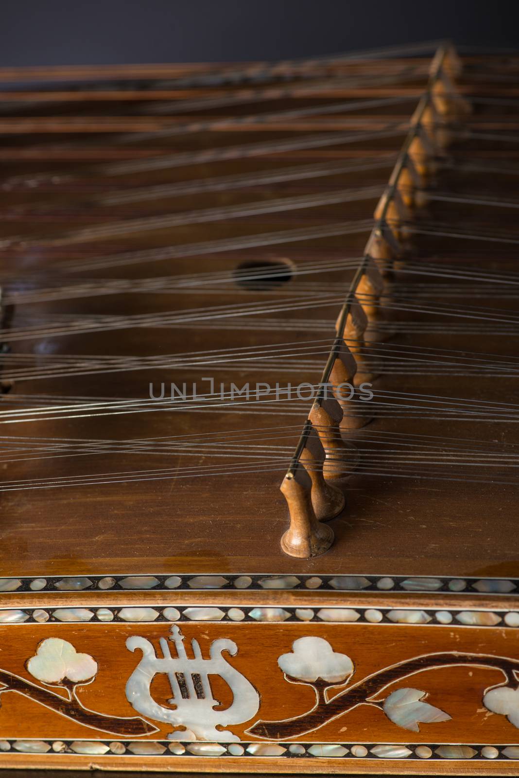 ancient Asian stringed musical instrument on black background with backlight. the similarity of the harp and psaltery. close-up