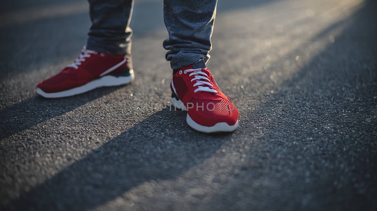 Man in sneakers walks down the street on a sunny day