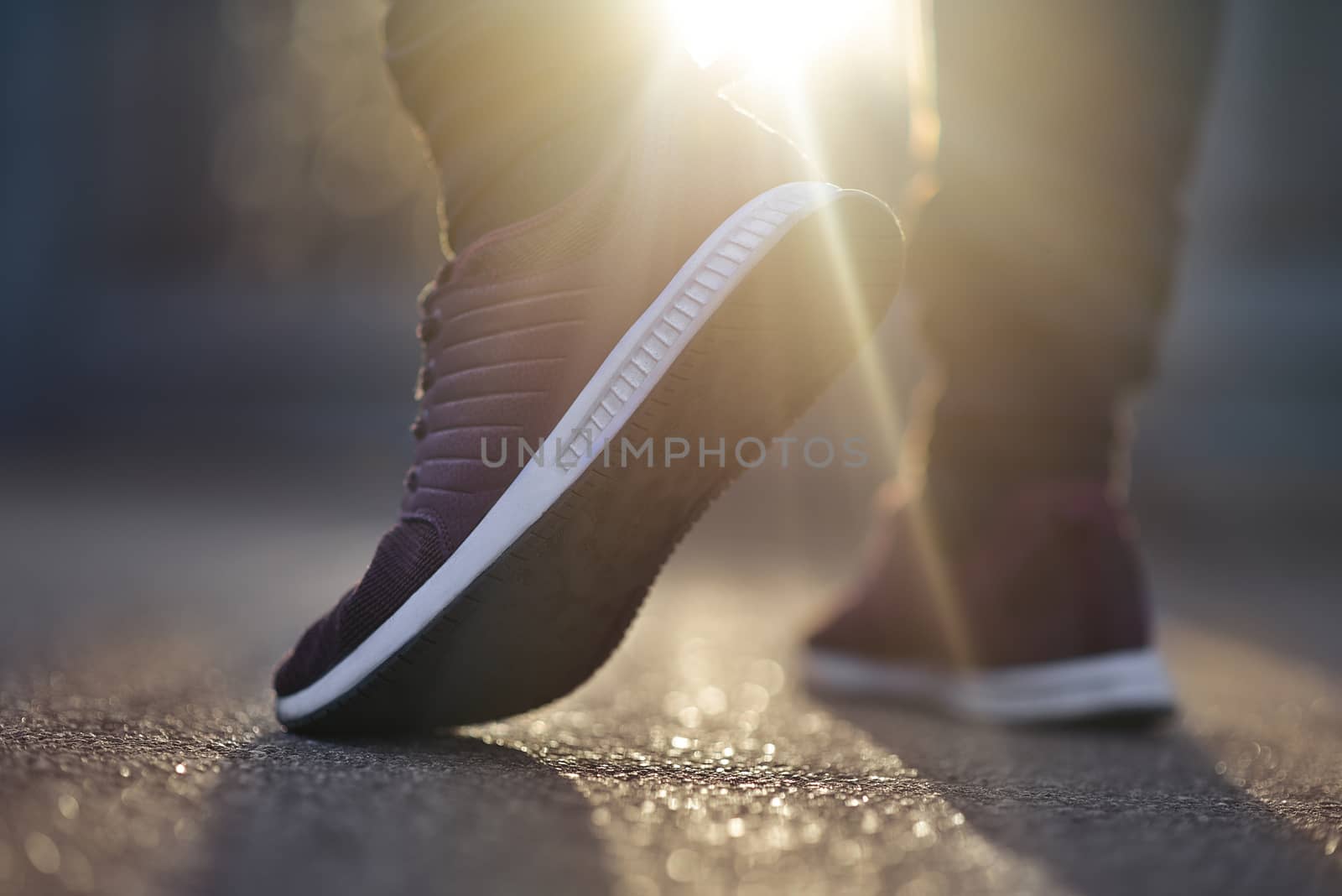 Man in sneakers walks down the street on a sunny day