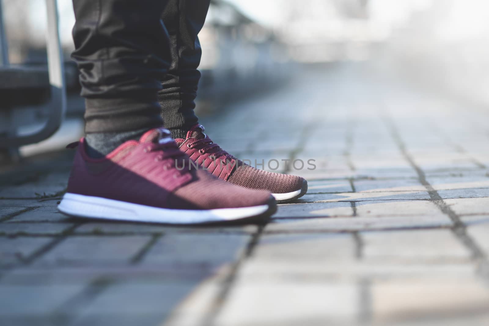 Man in sneakers walks down the street on a sunny day