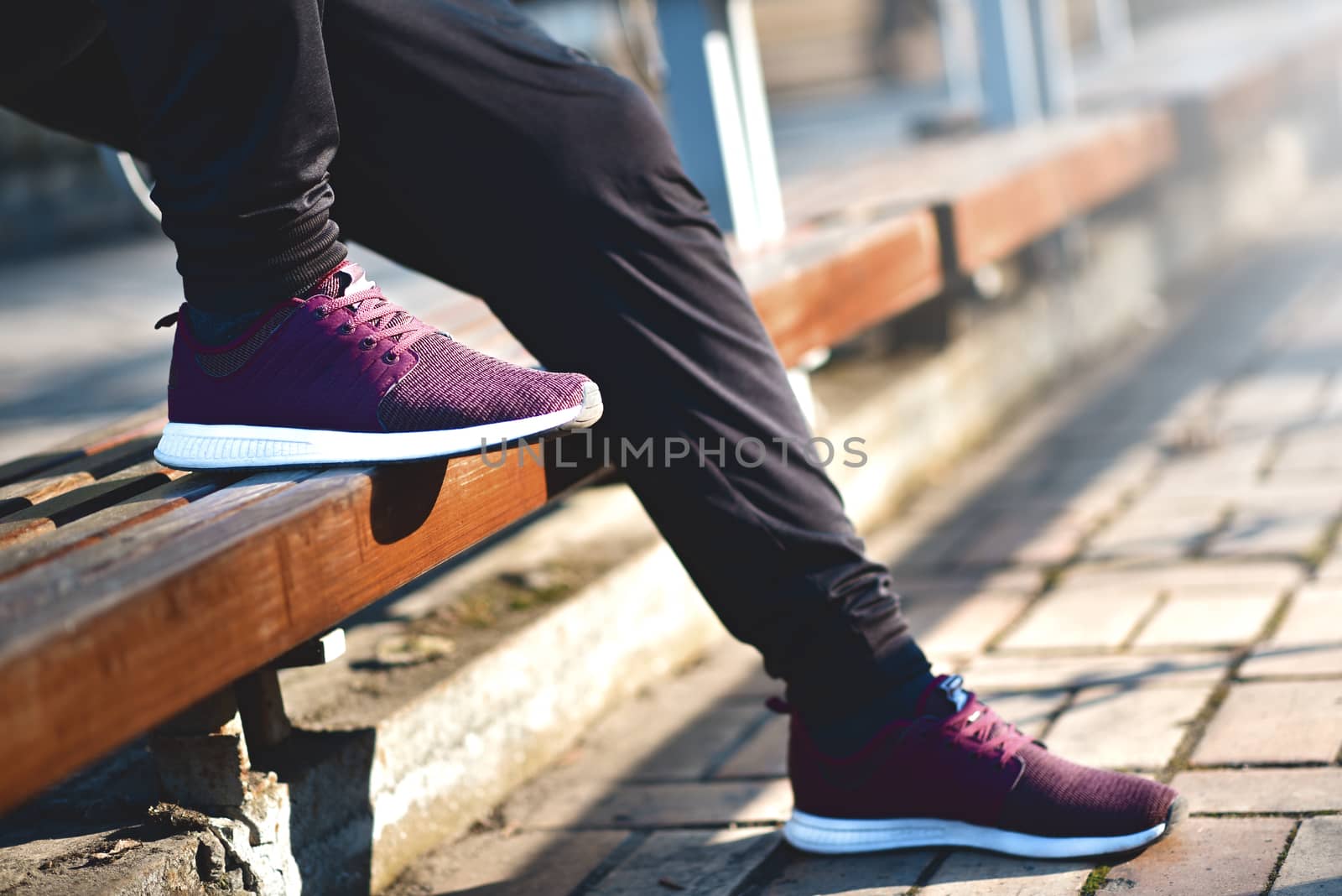 Man in sneakers walks down the street on a sunny day