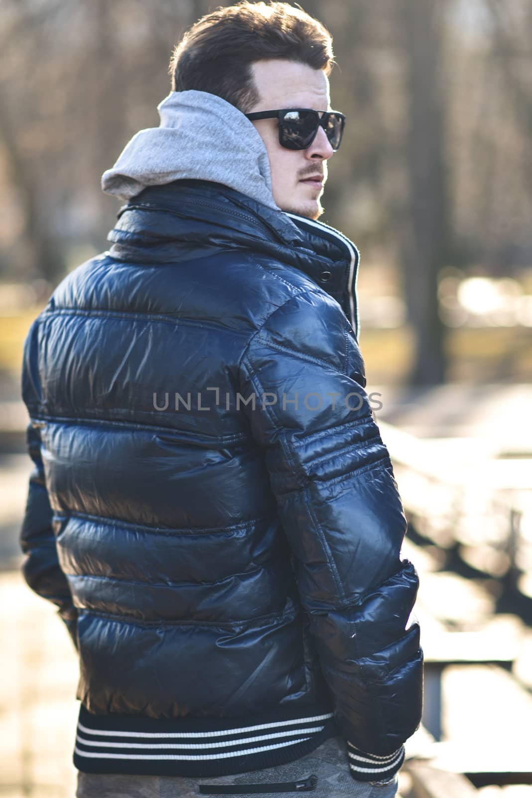 Portrait of attractive man in sunglasses with casual clothes walk in park