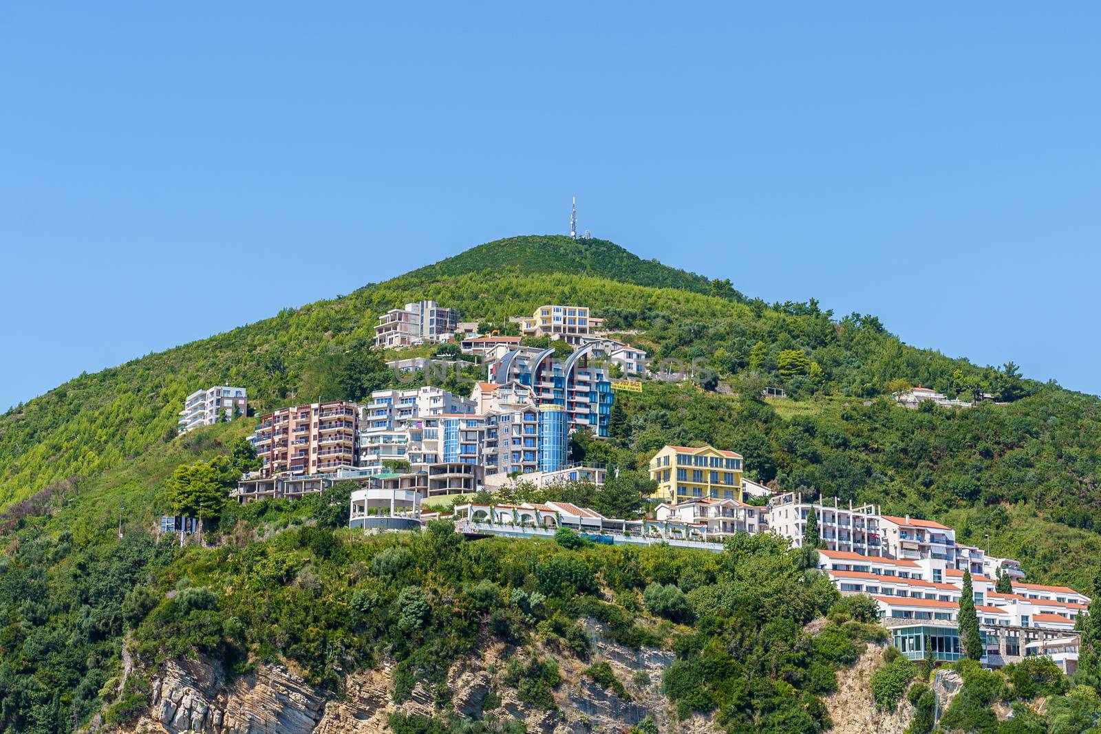 Hotel and resort buildings on a mountainside in the city of Budva, in Montenegro