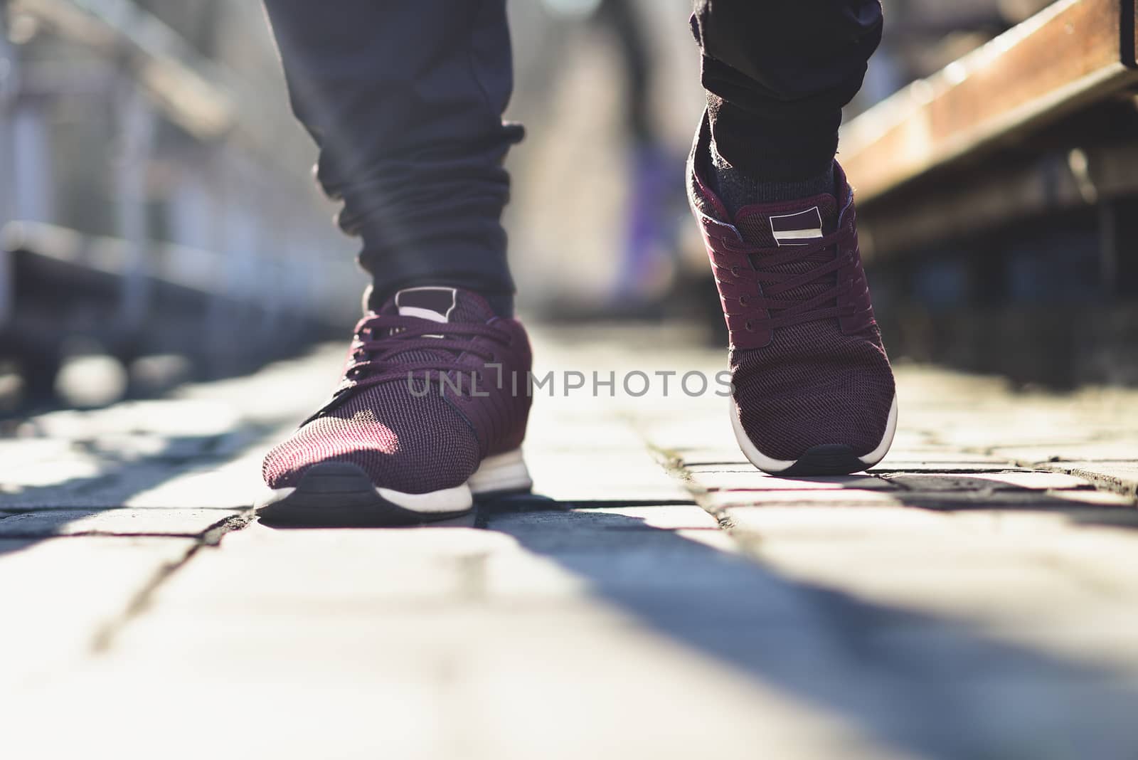 Man in sneakers walks down the street on a sunny day