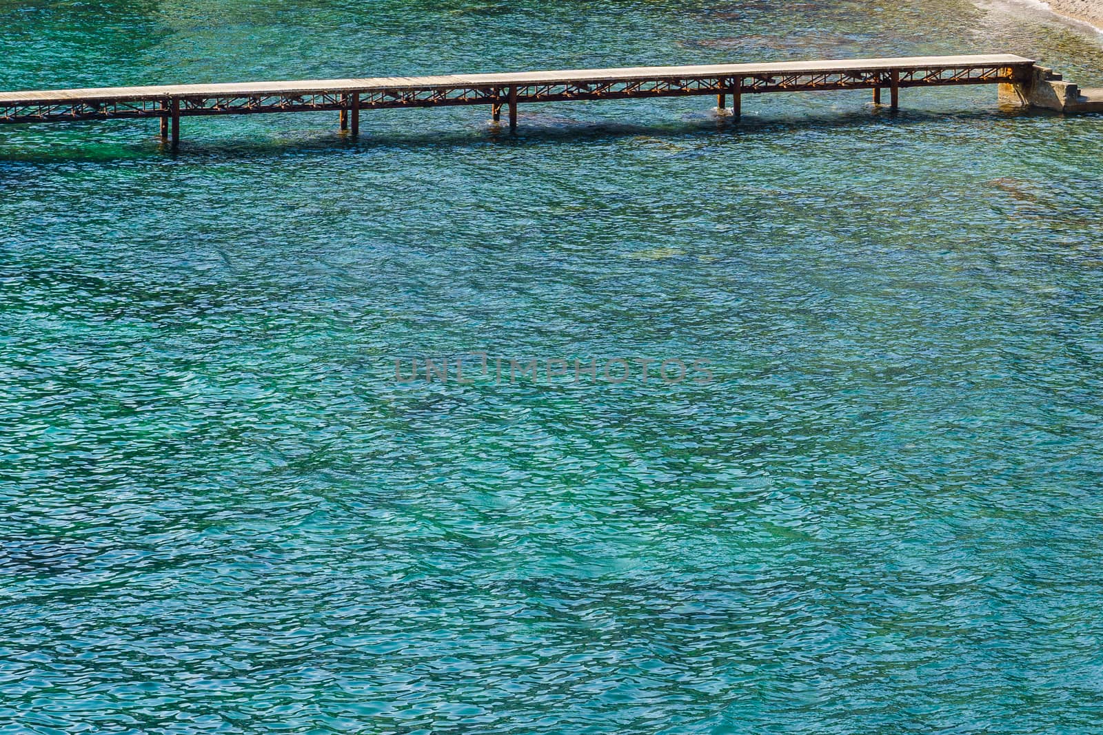 pier for swimming on a rocky beach on a sunny summer day