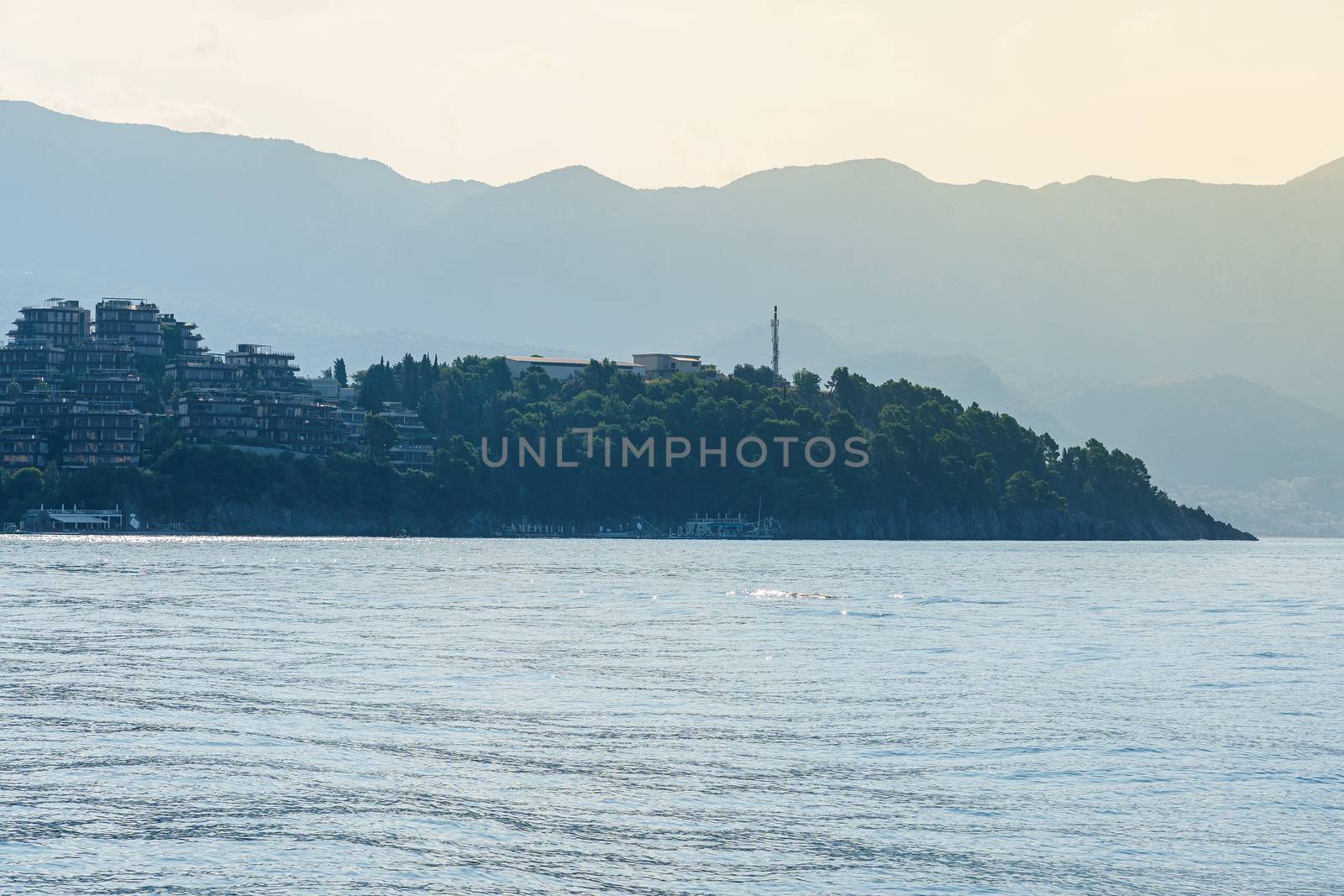 Seashore, a hill with buildings of hotels and resorts. View at sunset.