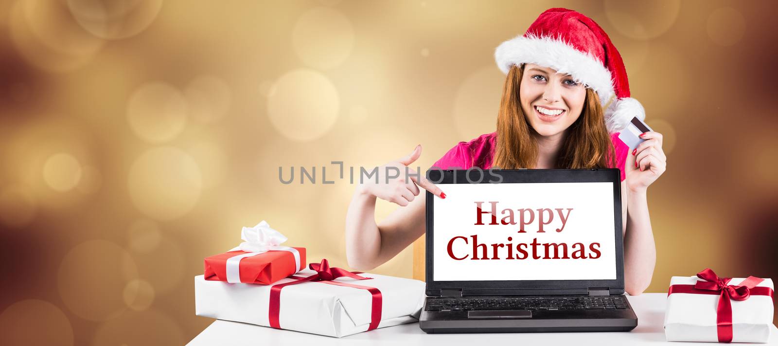 Composite image of festive redhead shopping online with laptop by Wavebreakmedia