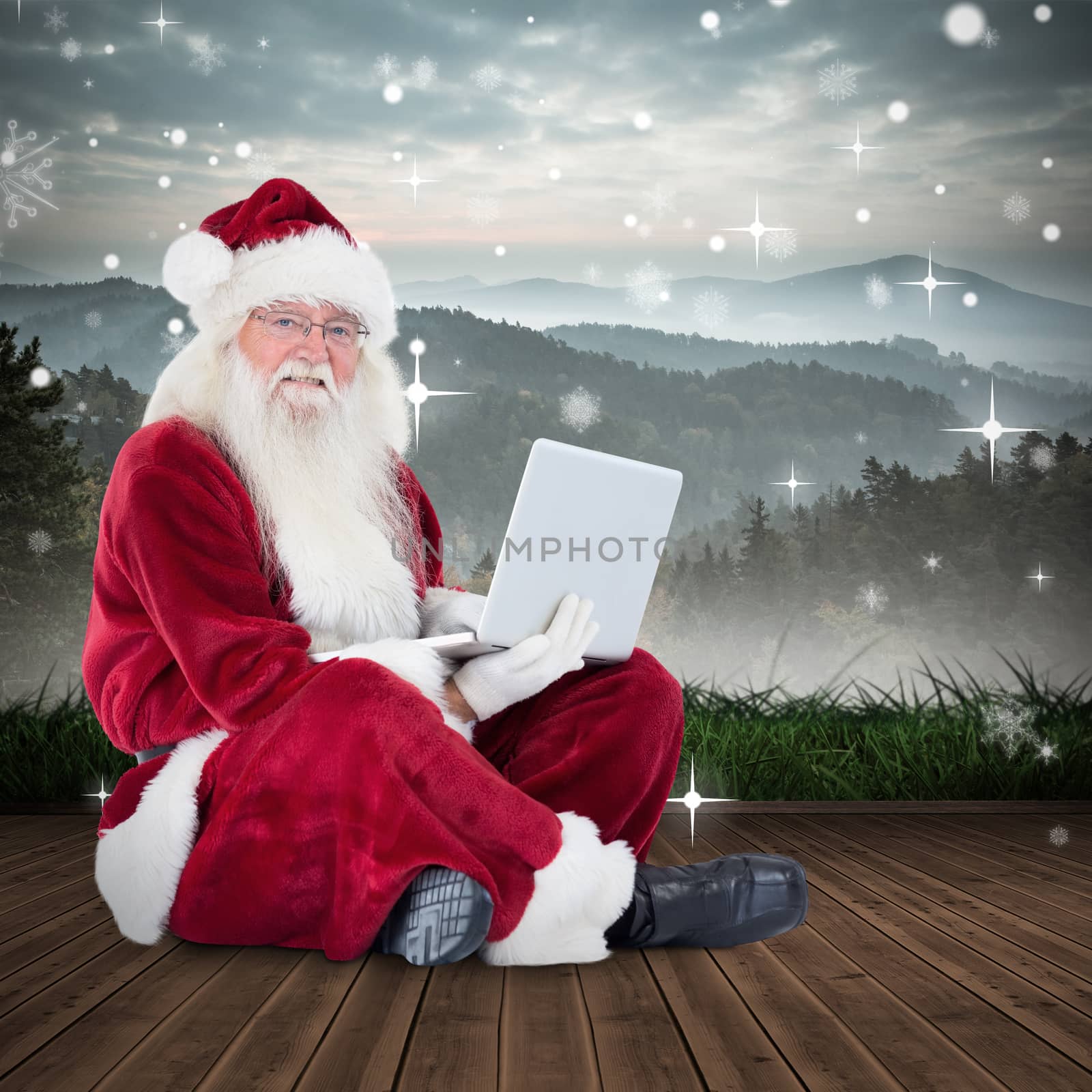 Composite image of santa sits and uses a laptop by Wavebreakmedia