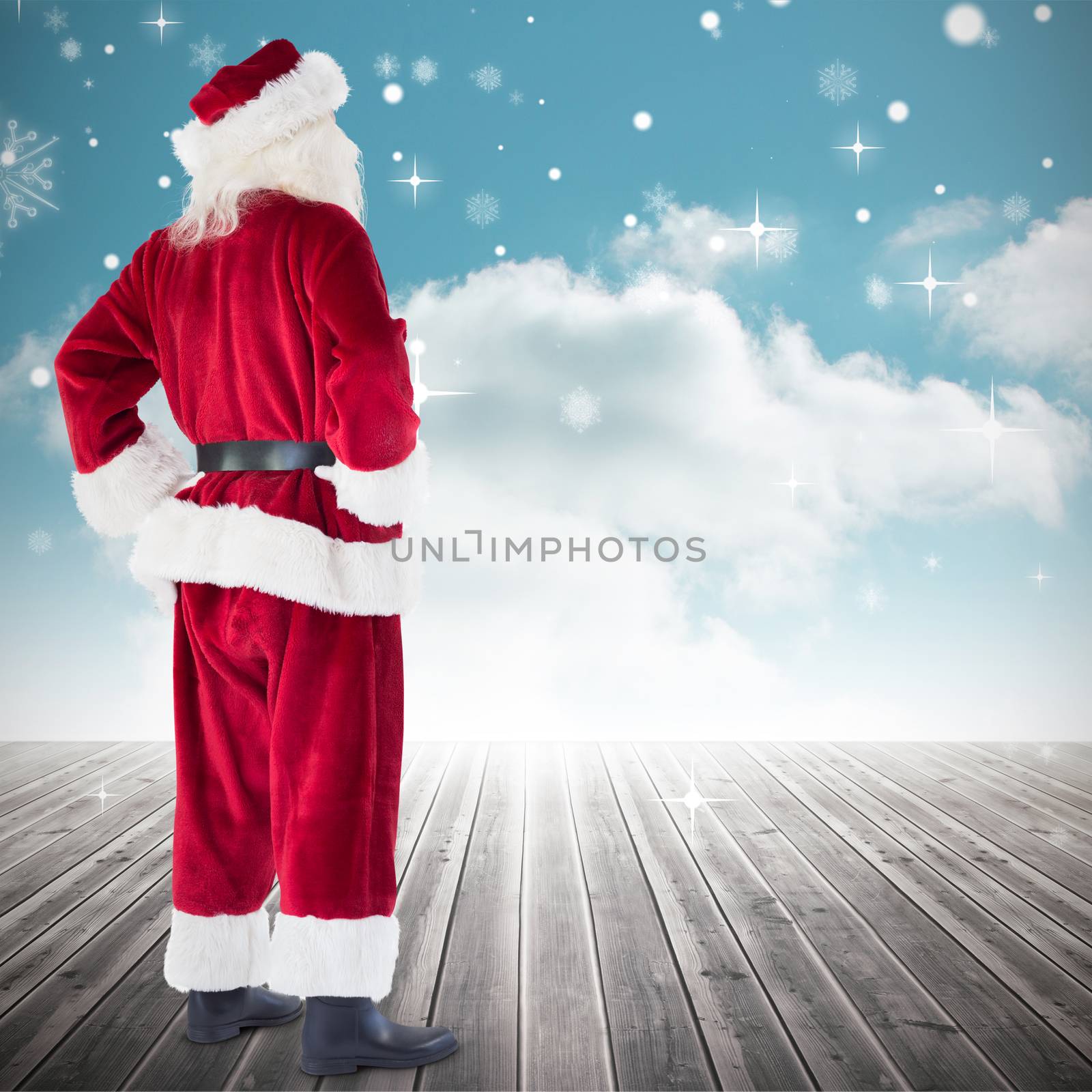 Santa with hands on hips against cloudy sky background