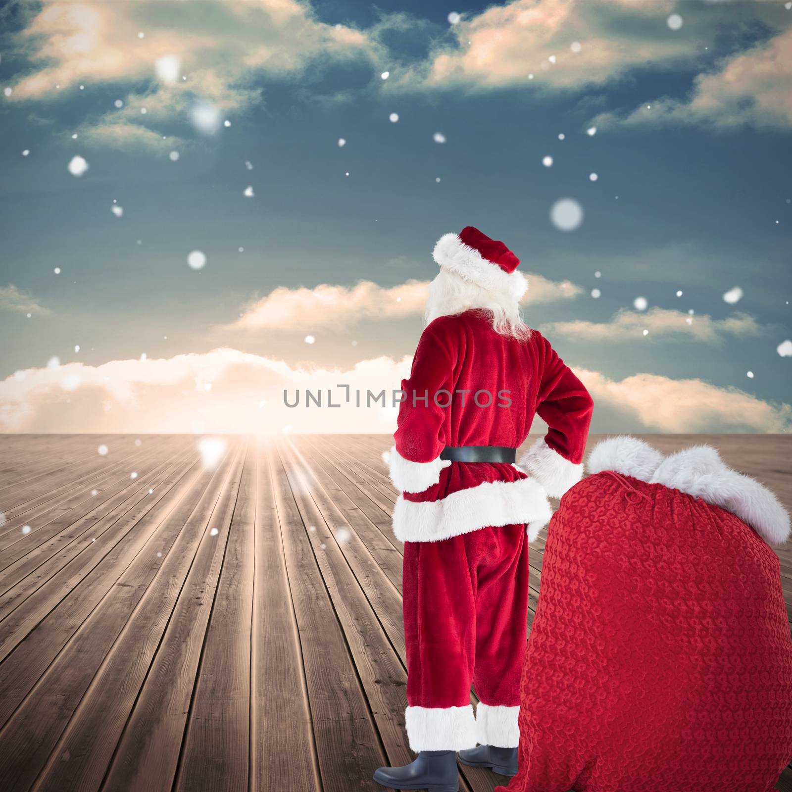 Happy santa with sack of gifts against wooden planks leading to blue sky