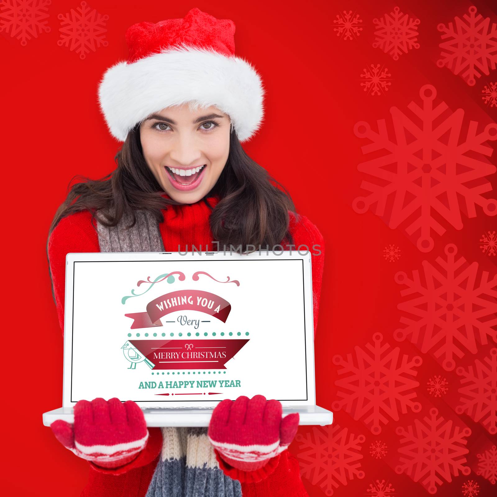 Composite image of festive brunette showing a laptop by Wavebreakmedia