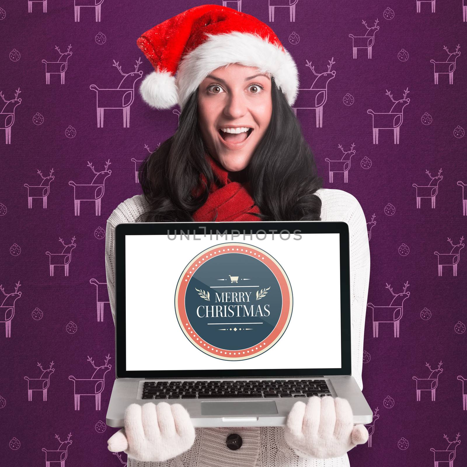 Smiling woman holding a laptop against purple reindeer pattern