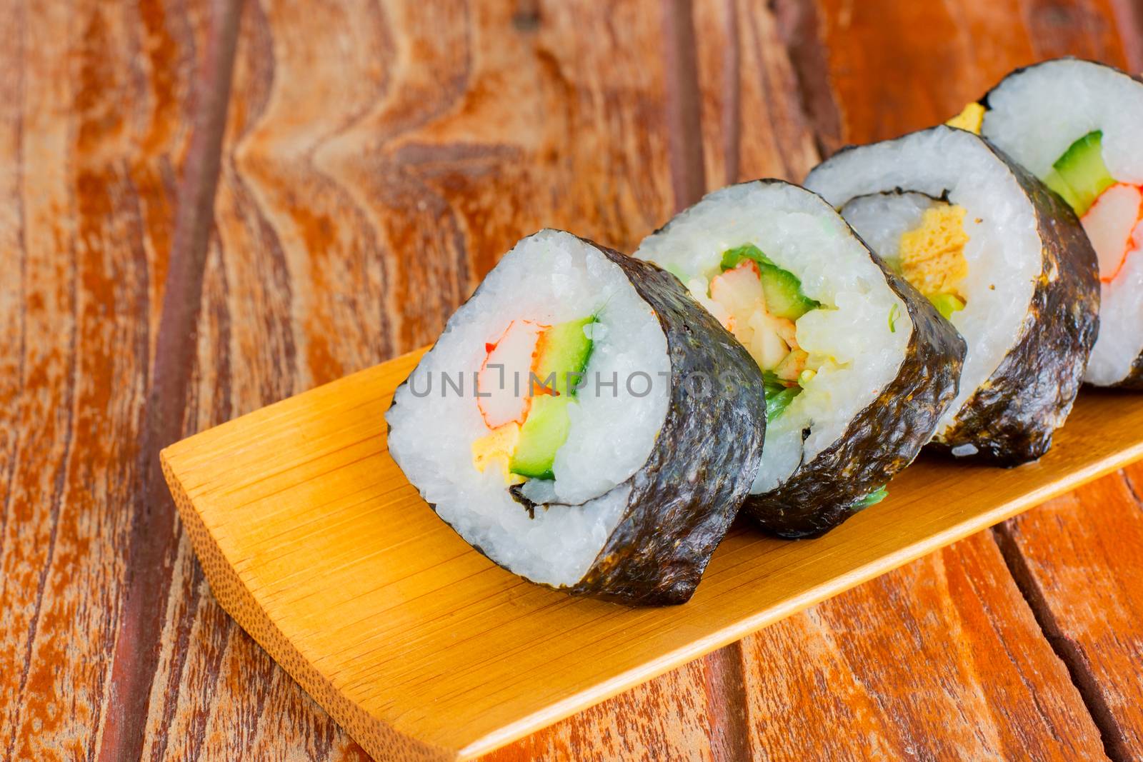 Tamagoyaki maki with seaweed wrap on wooden tray. Delicious japaneses food.