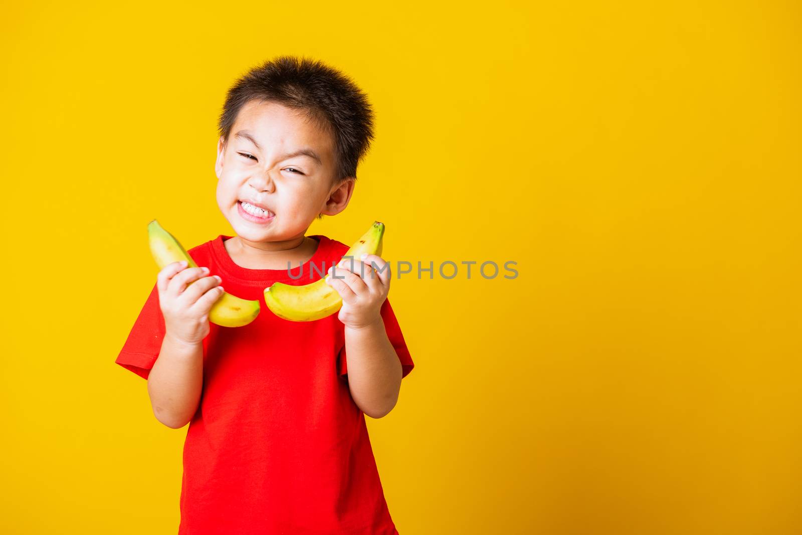 child or kid cute little boy attractive smile playing holds bana by Sorapop