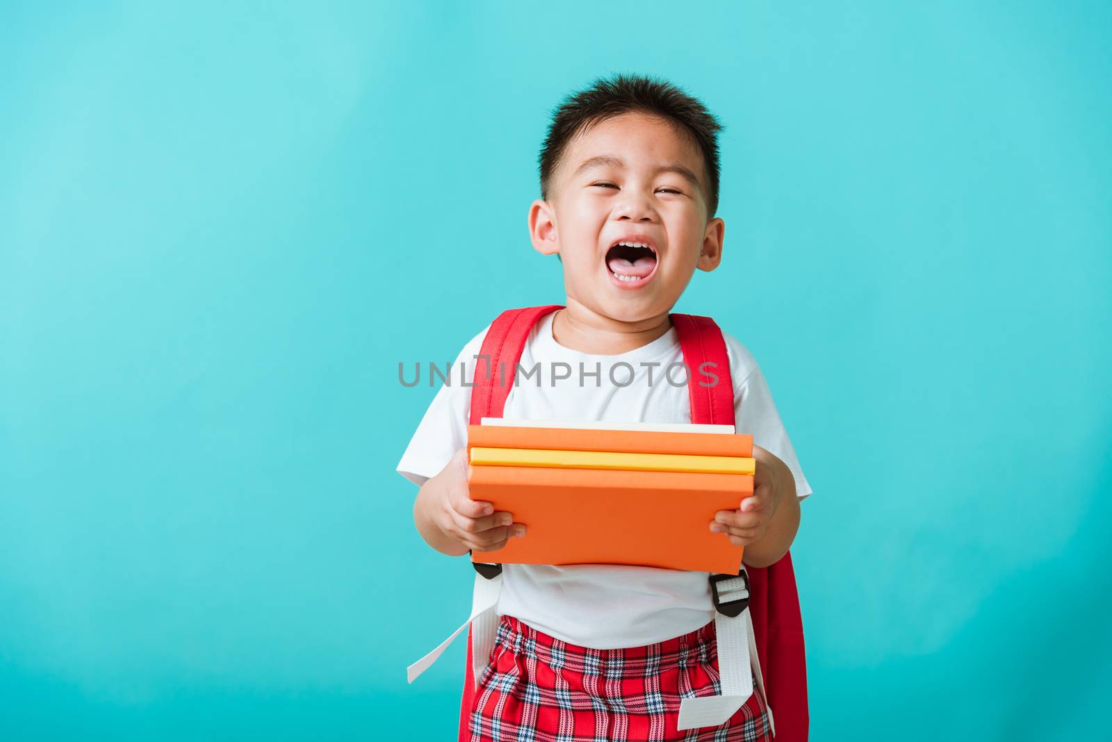 Kid from preschool kindergarten with book and school bag by Sorapop