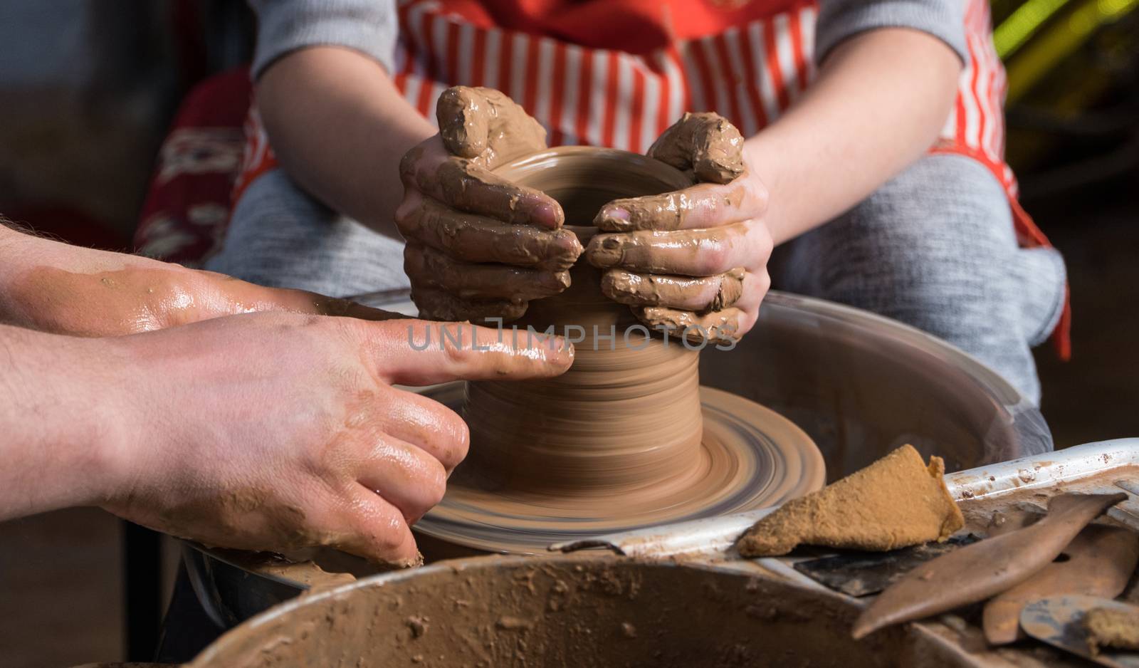 Teaching pottery to children. The teacher gives a master class in modeling