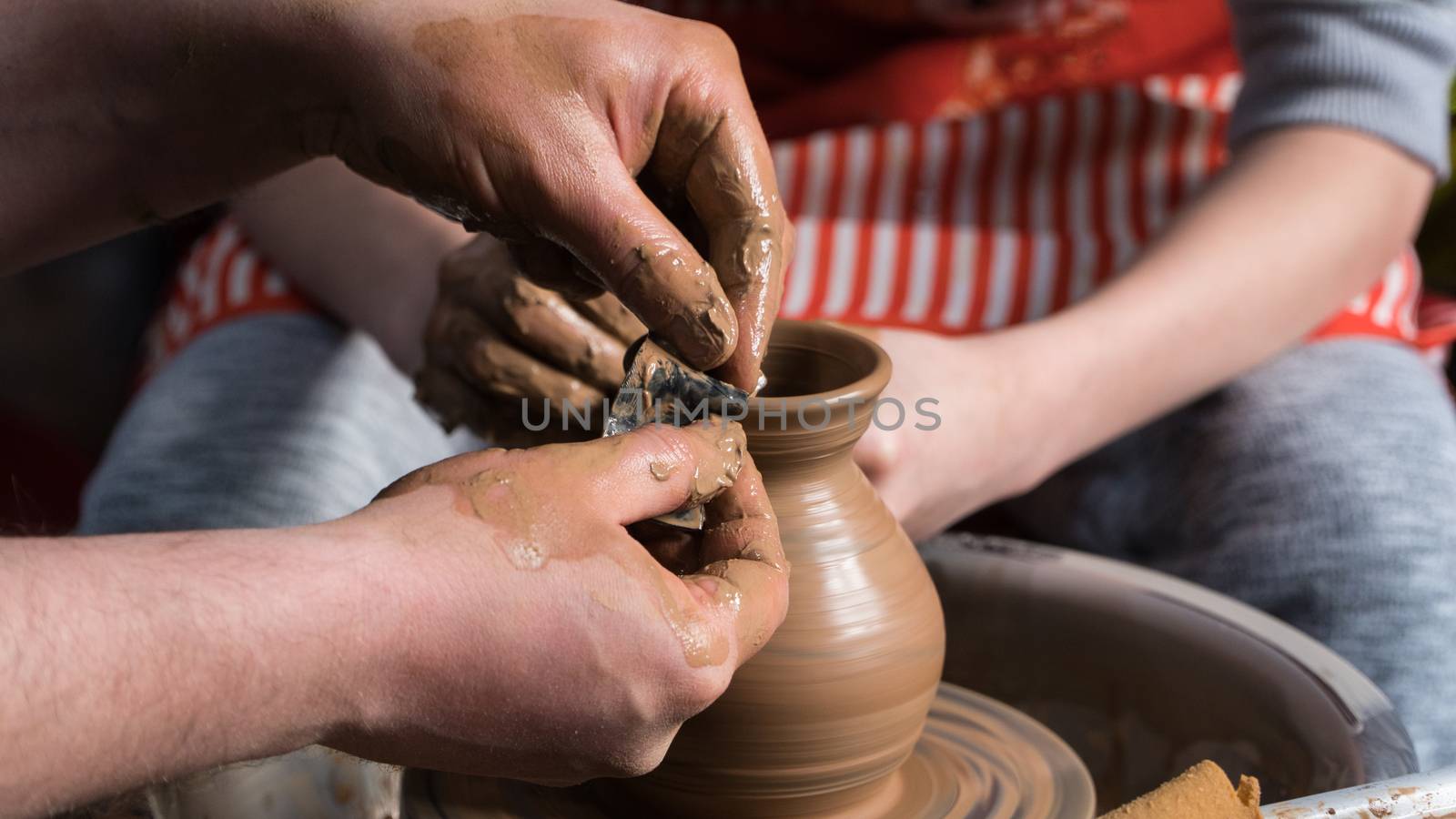 Teaching pottery to children. The teacher gives a master class in modeling