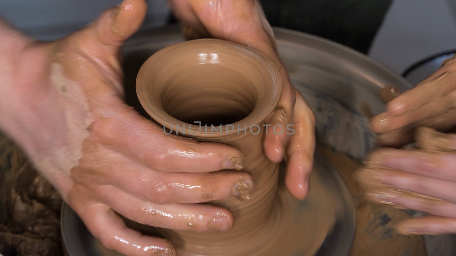 Teaching pottery to children. The teacher gives a master class in modeling