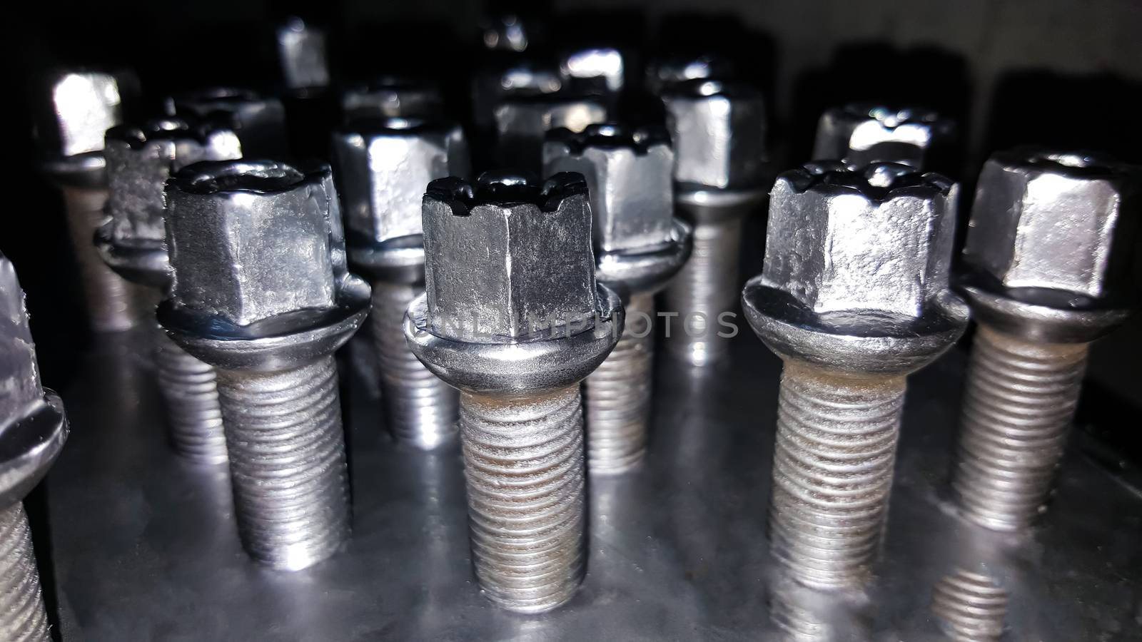 Large bolts of silver color. Screws on a silver tray.