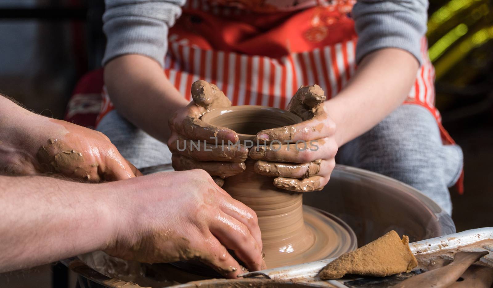 Teaching pottery to children. The teacher gives a master class in modeling