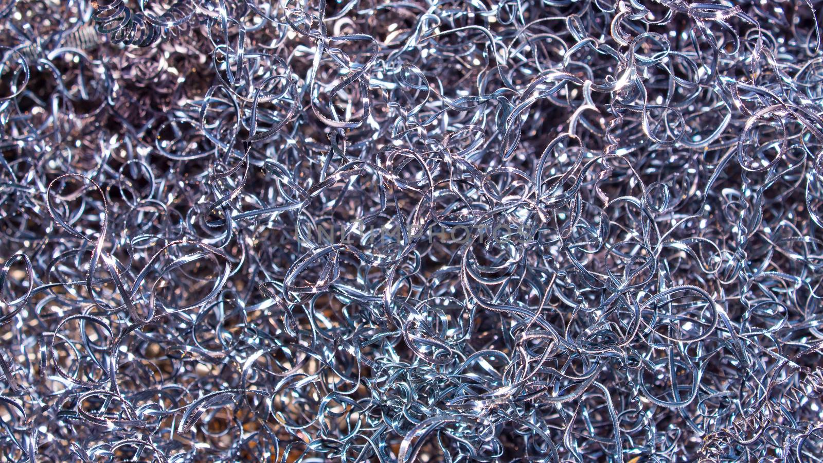 Metal background. Colored shavings. Wallpaper or screensaver of colored metallic chips.Abstract color background of metal shavings. Processing of ferrous and non-ferrous metals in a factory or plant