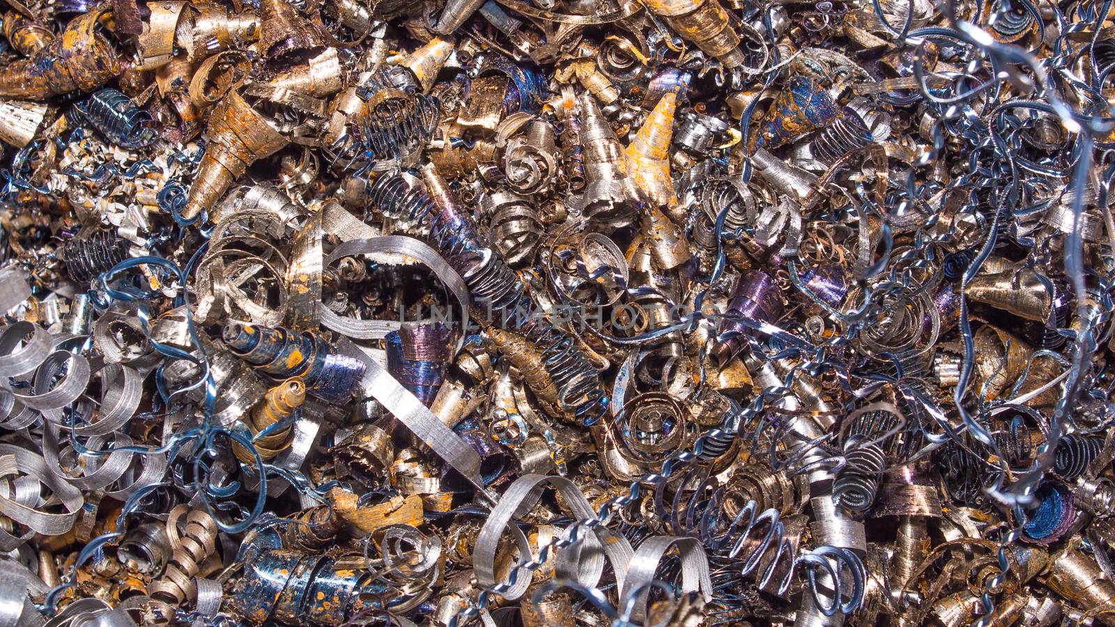 Metal background. Colored shavings. Wallpaper or screensaver of colored metallic chips.Abstract color background of metal shavings. Processing of ferrous and non-ferrous metals in a factory or plant