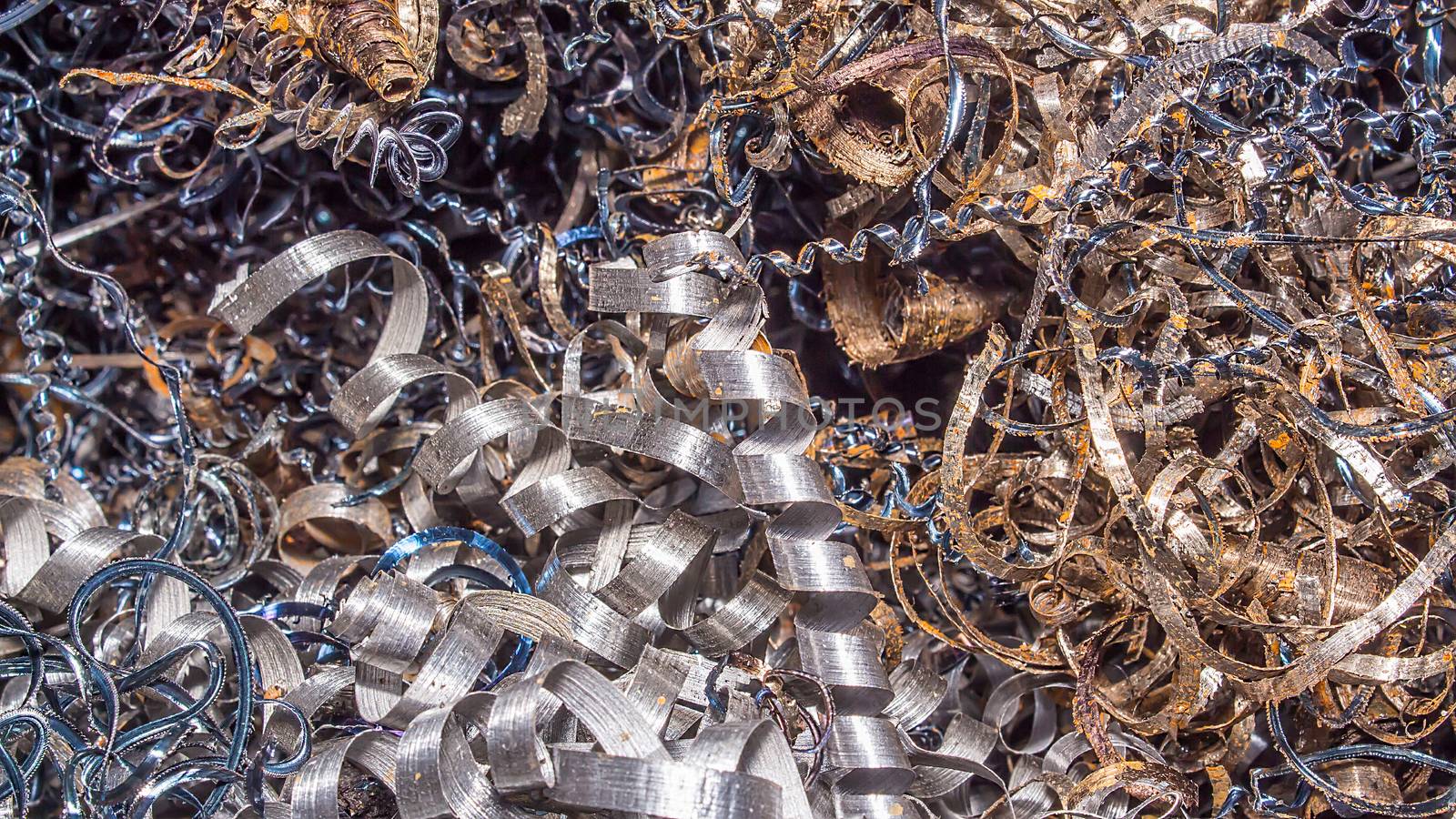 Metal background. Colored shavings. Wallpaper or screensaver of colored metallic chips.Abstract color background of metal shavings. Processing of ferrous and non-ferrous metals in a factory or plant