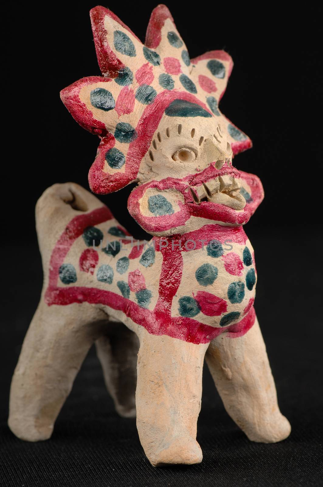 Asian and Oriental painted toy from burnt clay in the form of fantastic creatures and animals on a black background