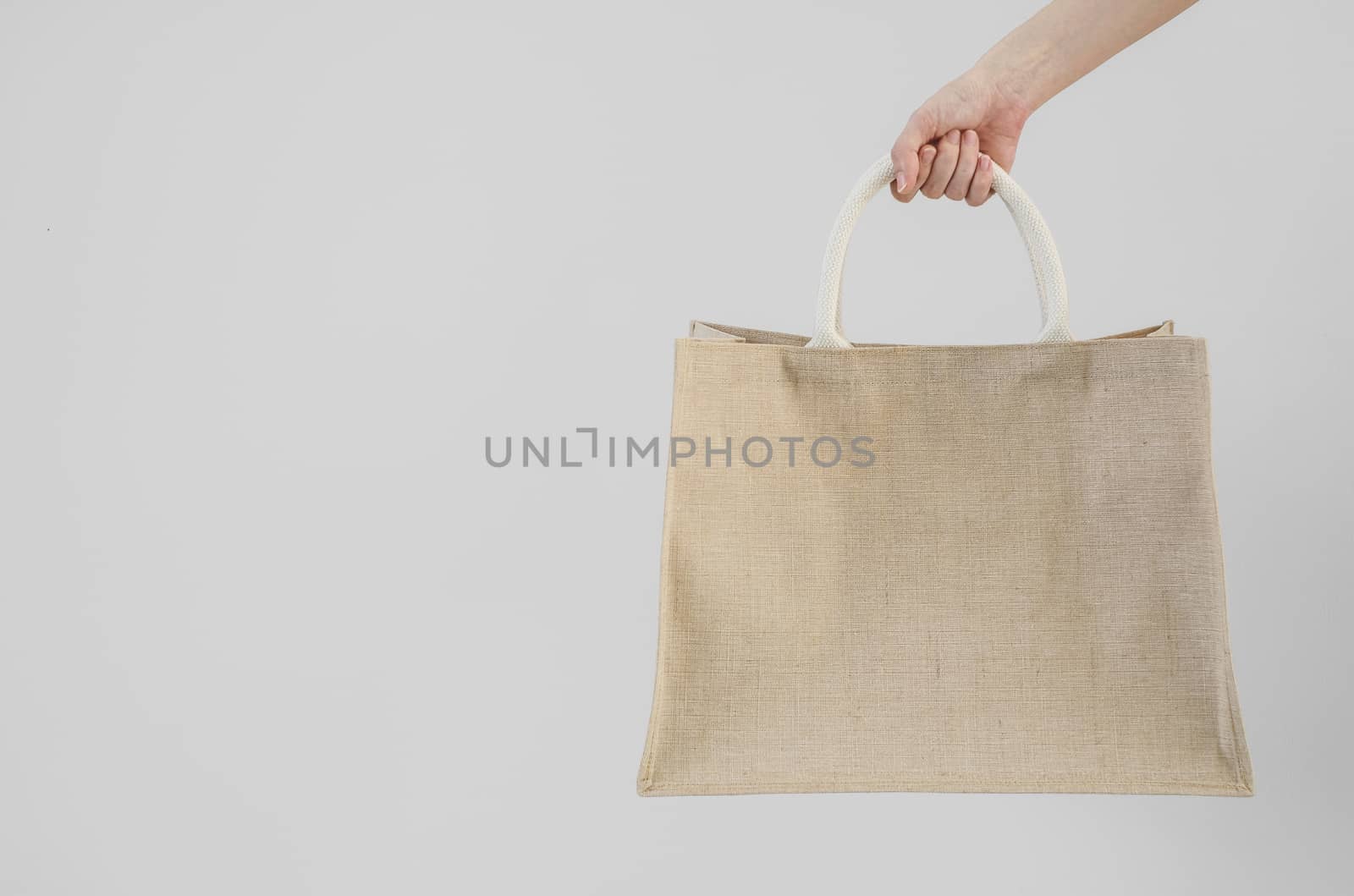 Woman hand holding sackcloth shopping bag with copy space No plastic bag concept