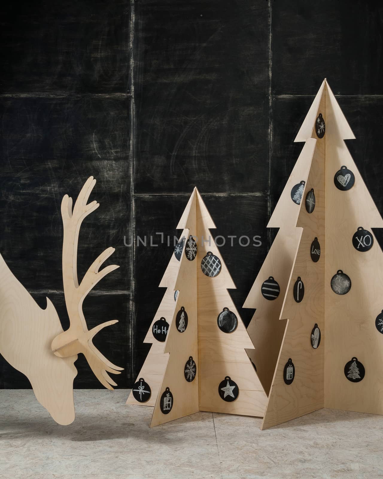 New Year's and Christmas decorations and fir plywood deer and a tree on a dark background