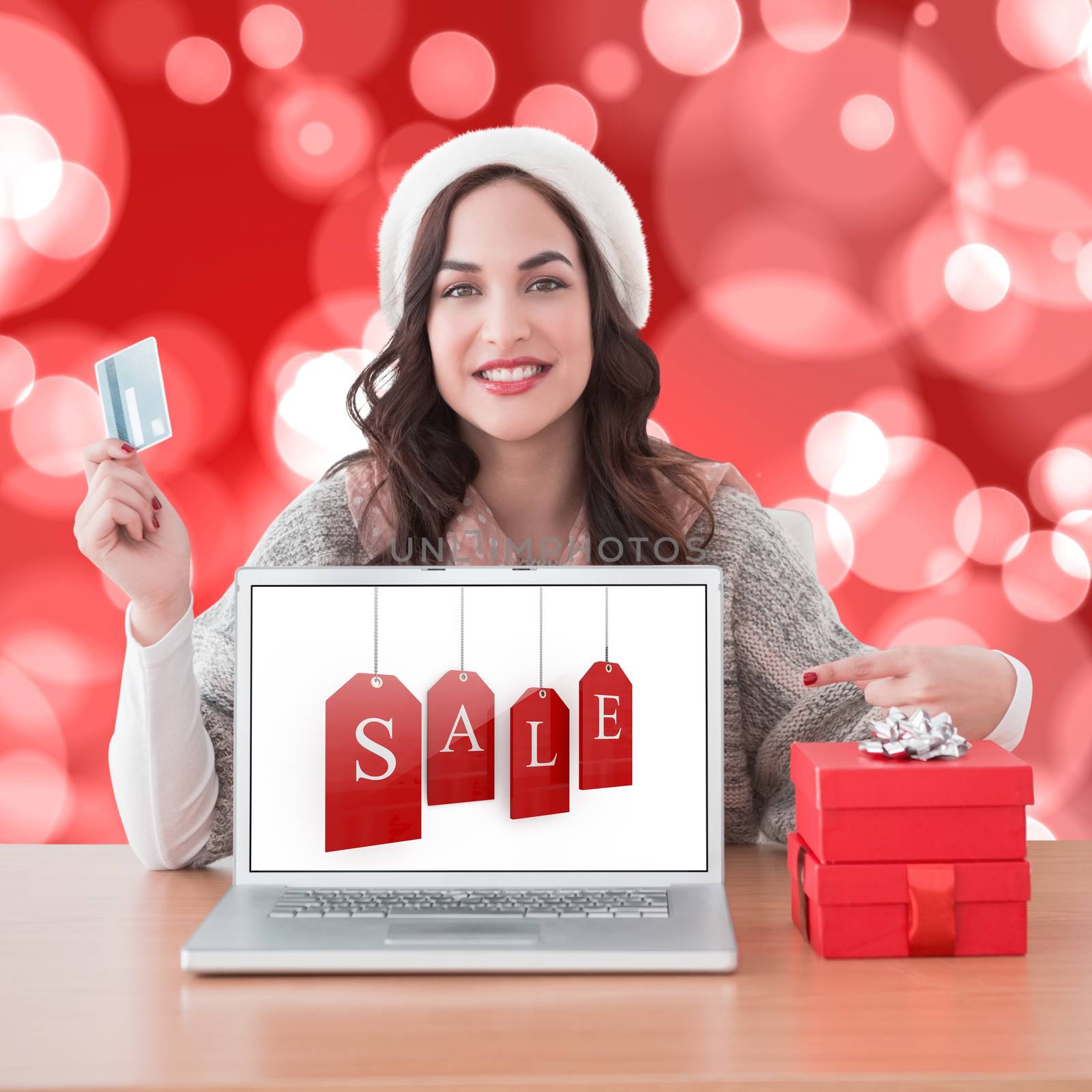 Composite image of festive brunette shopping online by Wavebreakmedia