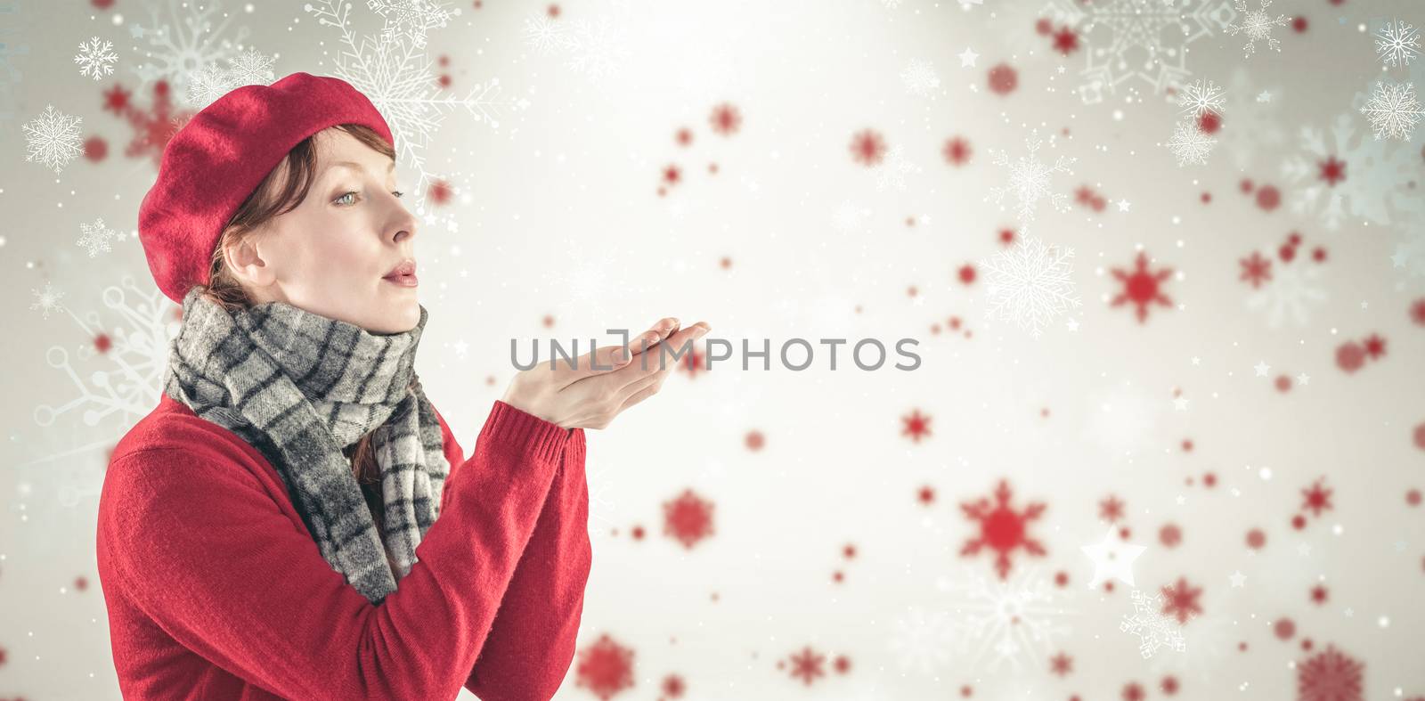 Woman blowing kiss from hands against snowflake pattern