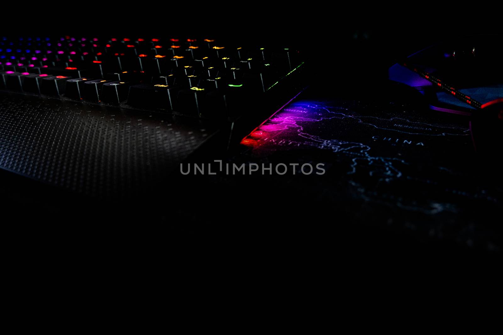 Back lighted computer gaming keyboard with RGB gradient colors, black space for putting text by peerapixs