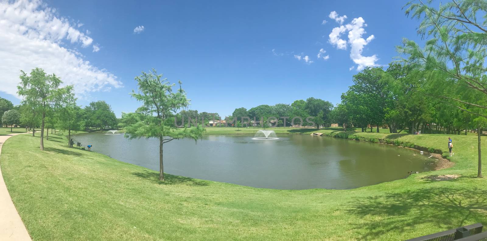 Panoramic view residential park with double floating fountains pathway and picnic bench in Coppell, Texas, USA by trongnguyen