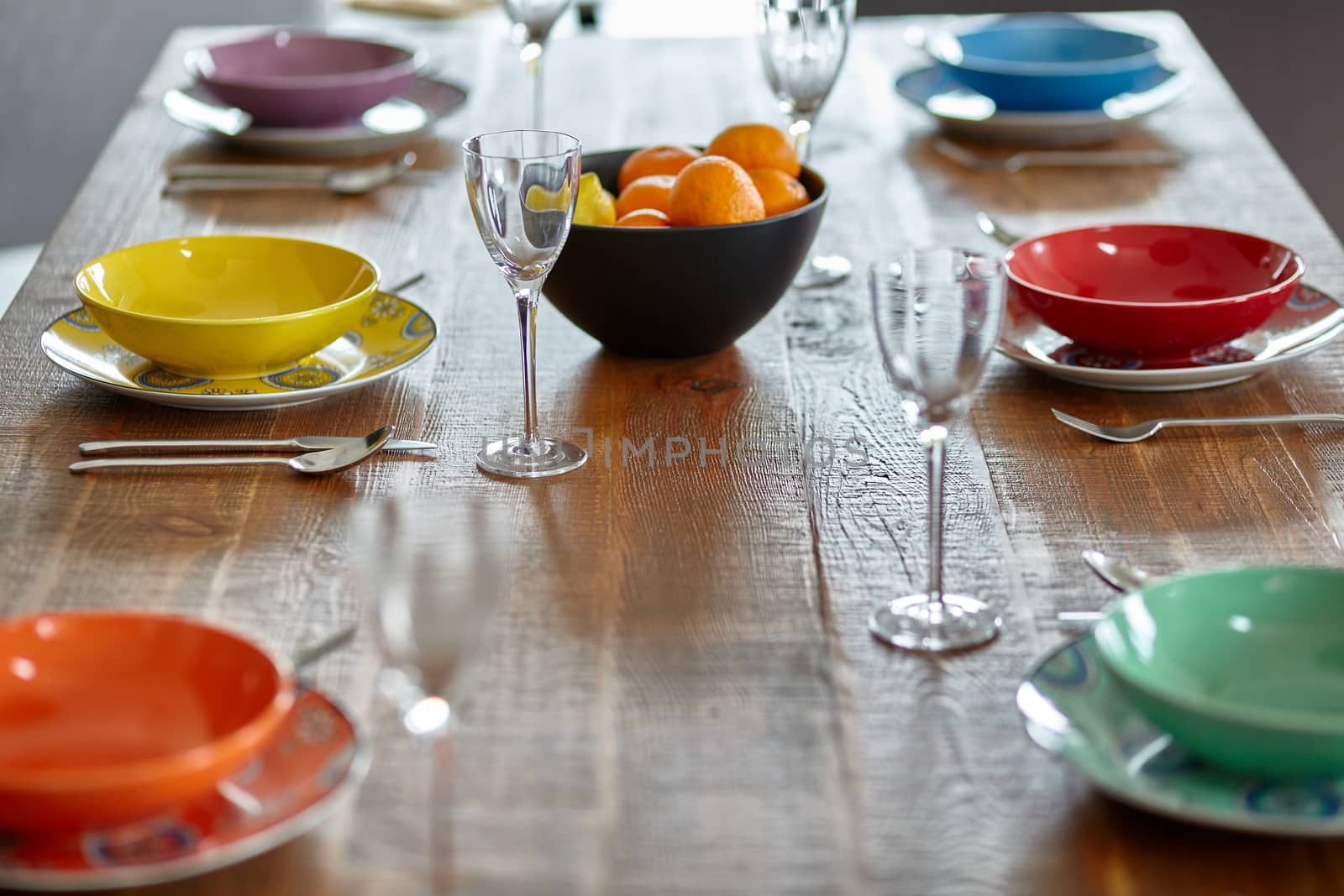 Wooden table with colourful dinnerware Small depth of field.