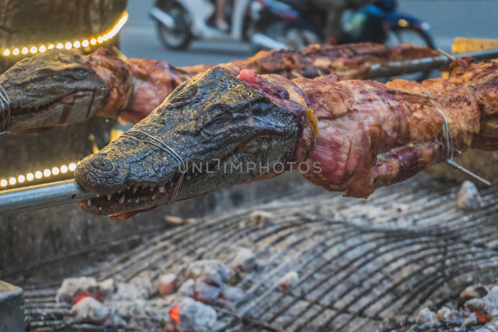 Grilled crocodile on the open fire at sea food restaurant, exotic meals in Viethnam, food of the asian cuisine, raw crocodile meat, exotic food.
