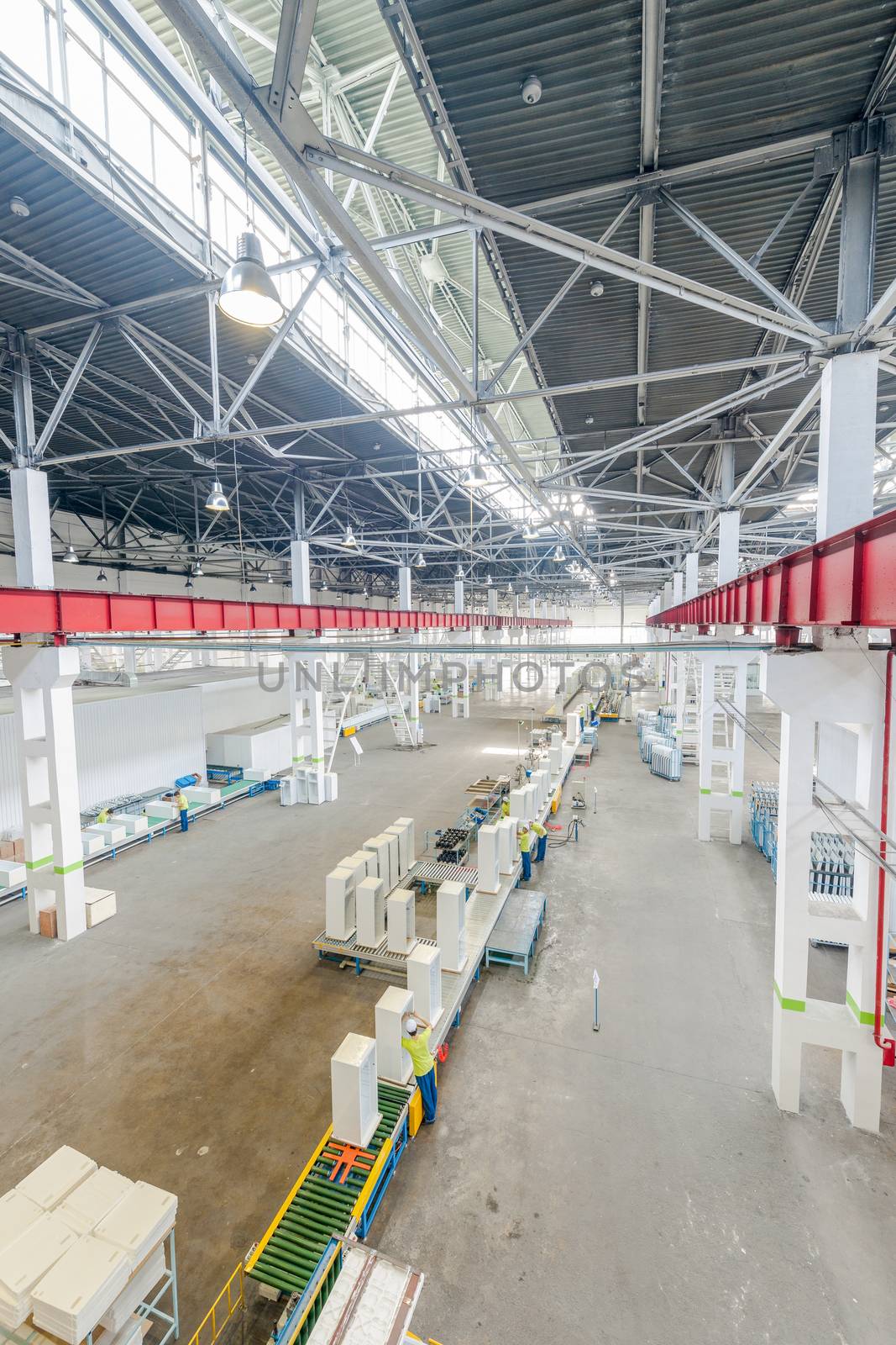 factory floor for production and assembly of household refrigerators on the conveyor belt. factory workers collect refrigerators on the conveyor belt