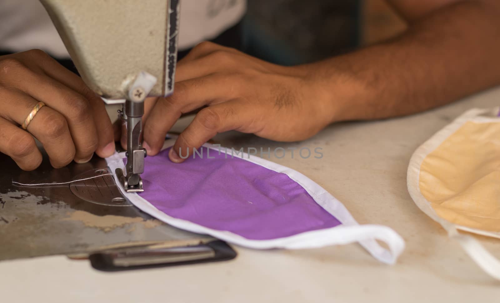 Home made diy protective mask against virus during mask shortage - Using sewing machine to sew the face medical mask during coronavirus or covid-19 pandemic. by lakshmiprasad.maski@gmai.com