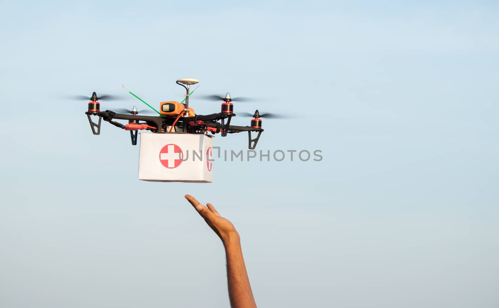 Hands receiving medical aid kit or medicines from drone or quadcopter during covid-19 or coronavirus lockdown - Medical Industry Logistics for Drug Transport concept during lockdown by lakshmiprasad.maski@gmai.com