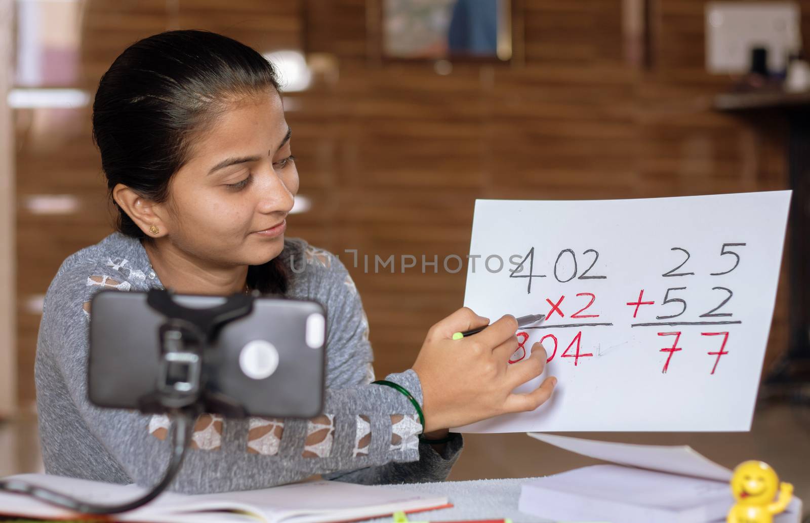 Girl taking online virtual class on mobile phone, busy in teaching at home during covid-19 or coronavirus pandemic crisis - Concept of e-teaching, online education or self isolation