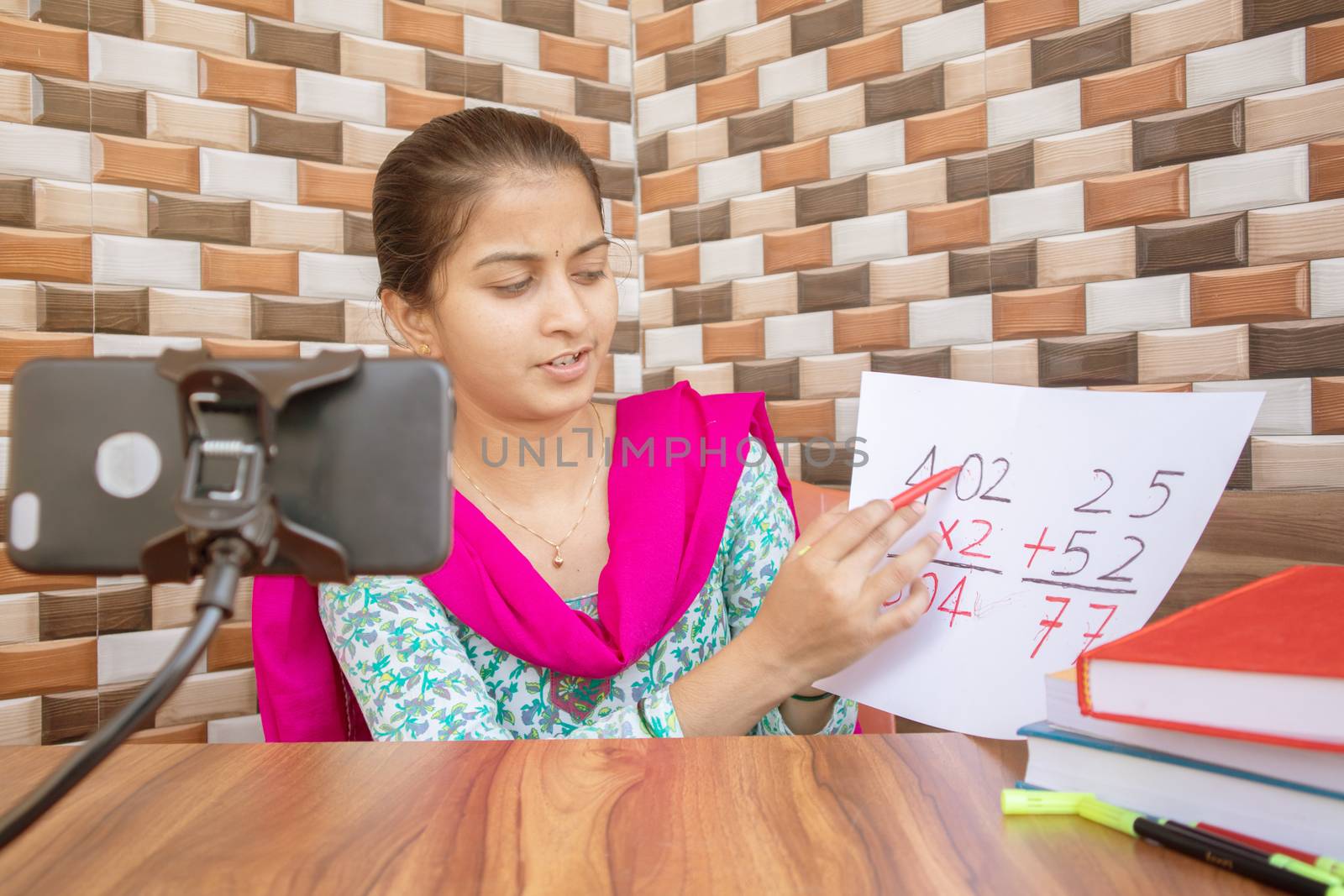 Girl taking online virtual class on mobile phone, busy in teaching at home during covid-19 or coronavirus pandemic crisis - Concept of e-teaching, online education or self isolation. by lakshmiprasad.maski@gmai.com