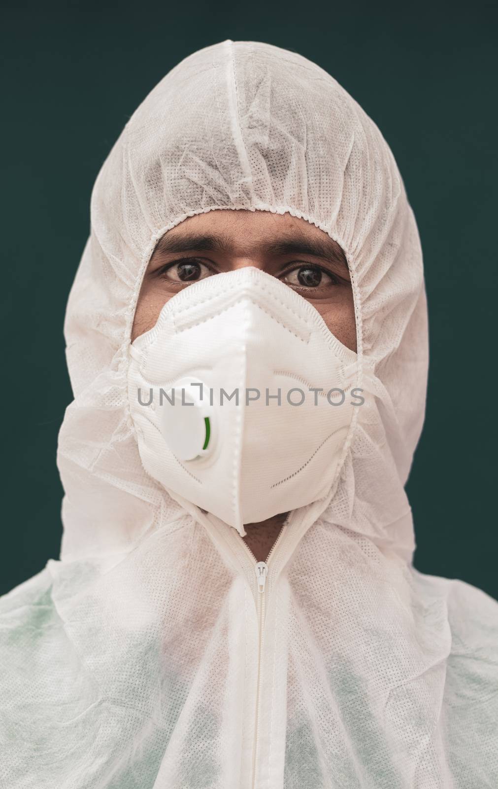 Close up portrait of doctor with protective suite and medical N95 Face Mask looking at camera - concept of doctors at coronavirus or covid 19 screening process. by lakshmiprasad.maski@gmai.com